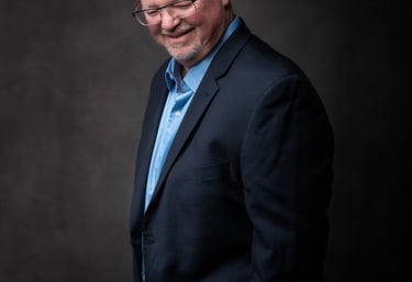 a professional image of a man in a suit and tie smiling