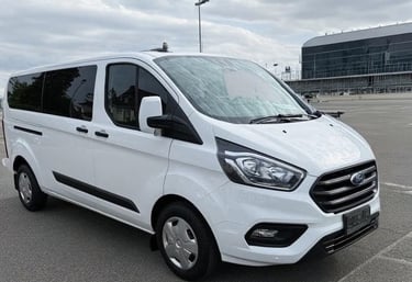 a white van parked in an airport parking lot