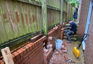 a man is fixing a damaged brick wall
