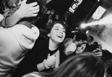 Besijuokianti moteris šoka minioje per muzikinį koncertą.