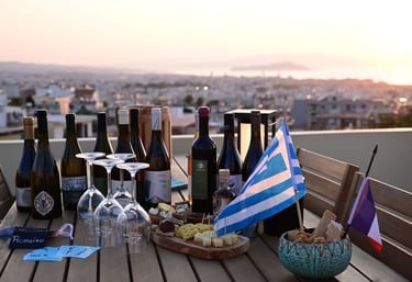 a table with greek wine bottles and glasses on it at La Canée