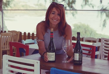 a sommeliere sitting at a table with wine glasses and greek bottles of wine in chania