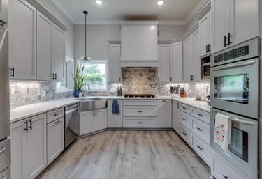 A photo of a remodeled kitchen with light cabinets and wooden floors.