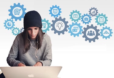 a woman sitting at a table with a laptop and a laptop