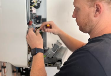 A Gas Safe engineer performs a boiler service and electrical repairs on a wall-mounted heating system.