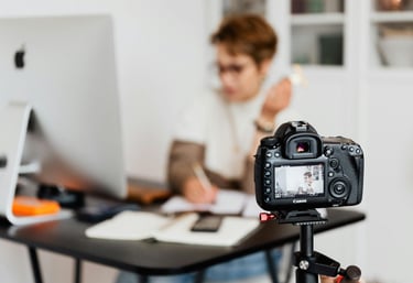 a woman sitting at a desk with a camera and a camera