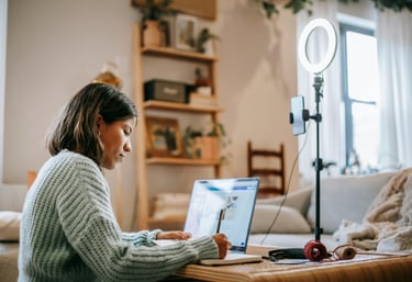 a woman sitting at a table with a laptop computer