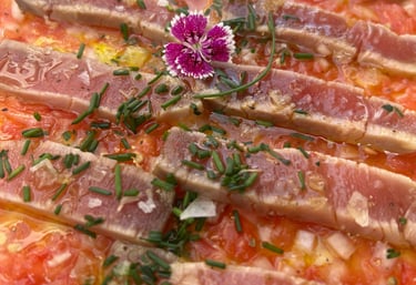 Plato de bigote de atún del Bar Las Tinajas Huelva, presentado con una flor decorativa encima.