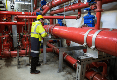 Man working on a fire sprinkler pipe