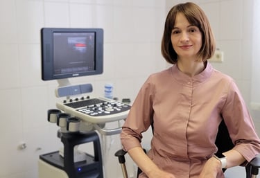 A doctor sits behind an ultrasound machine.