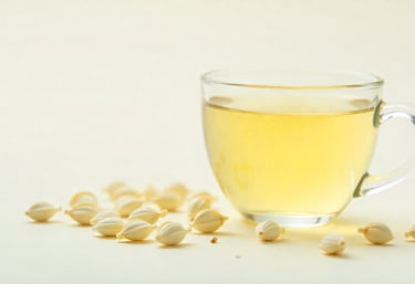 Pale white tea in glass cup with tea buds on white background.
