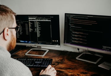 a man looking to a computer screen, looks like he is working on design of a website. 