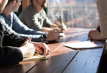 Group meeting around wooden table discussing client-centric approach