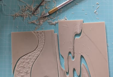 a jigsaw linocut print being assembled with printmaking tools on desk