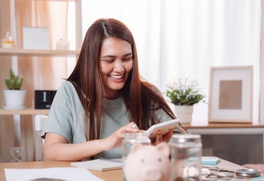a woman sitting at a table with a piggy