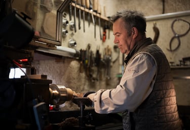 Artisan travaillant soigneusement une pièce de bois sur un tour à bois dans son atelier. L'atmosphèr