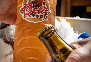 la mano de una persona sosteniendo una botellas de cerveza artesanal