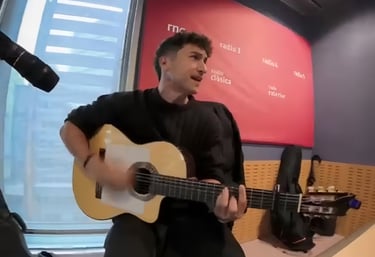 A male musician playing an spanish guitar during a live performance at the RNE radio studio.