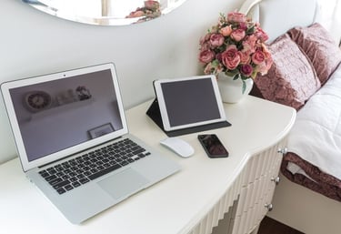 TechAid spec laptop computer sitting on a desk with a vase of flowers