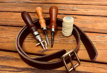 a leather belt strap with a thread spools and leather tools