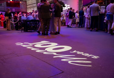 Eventlocation mit stehenden Personen und dem Schriftzug 100 years Lamotte