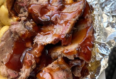 Signature One Eye Willy brisket mac and cheese—Texas-style smoked brisket over four-cheese macaroni with BBQ drizzle, served 