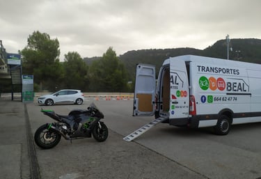 Furgoneta de Transportes Beal con rampa desplegada, lista para cargar una motocicleta.