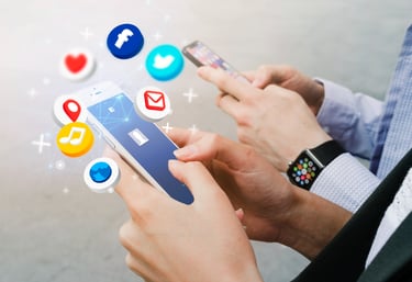 الصورة تظهر يدين تحملان هاتفاً ذكياً، ويرتدي الشخص ساعة أبل الذكية. تتطاير من الهاتف أيقونات مواقع التواصل الاجتماعي المختلفة