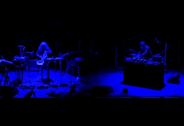 Nomads Spirits duo live performance, trumpet and percussion under blue stage lights