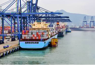Container ship docking at sea port with cargo cranes and containers in background.