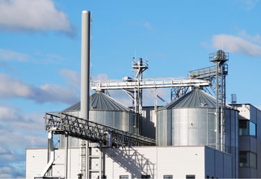 Industrial factory with silos and pipelines, illustrating perimeter monitoring and fire alarm integration for manufacturing