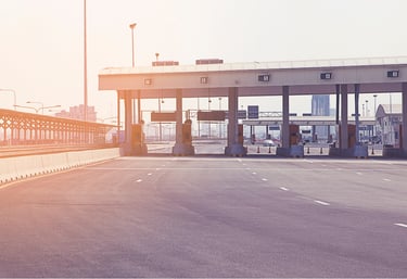 Empty highway toll plaza with sunlight representing an automated toll collection system.