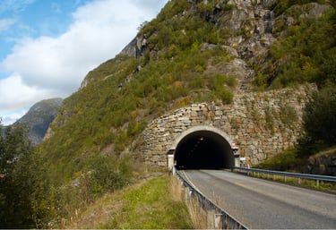 Stone-structured tunnel entrance on a mountain road for rural tunnel traffic and safety monitoring solutions.