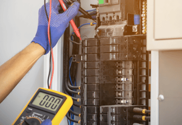 An electrician in Bangs testing the electric panel at the home of a customer