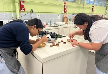 兩位學員在甜品製作枱前細心擠上裝飾，專注神情映照學習熱情，每個細節散發童真與創作喜悅。