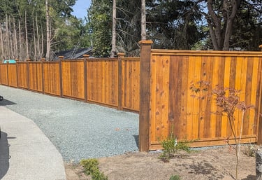 New spray-stained fencing, with tamped and leveled gravel service area