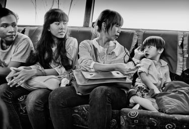 3 Indonesian women look at a young child on a Jakarta bus by photographer Peter Pickering