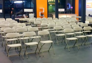 Sillas blancas plegables para eventos corporativos en el paso