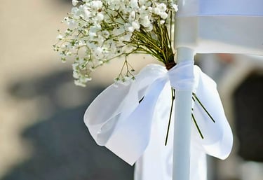 Silla para boda decorada con un liston blanco y flores
