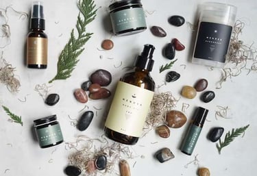 Flat lay of skincare products with herbs and stones on a white background