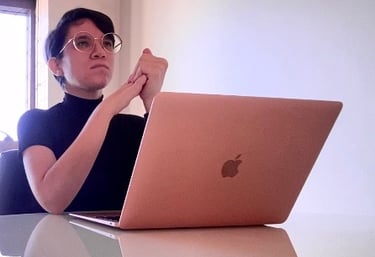 a woman sitting at a table with a laptop computer