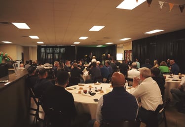 a group of people sitting at tables in a room for event