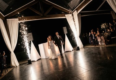 Bride and groom entering their outdoor wedding reception with cold sparkler fountains.
