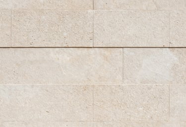 Texture photography of a light stone wall with subtle shadows, Spanish-speaking architectural style, clean and timeless aesthetic.