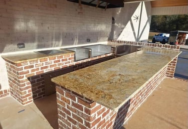 Granite countertop installed in outdoor kitchen with grill setup