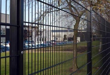 grade de metal na cor preta cercando um estacionamento