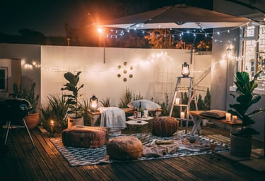 A cozy patio featuring decorative lights and vibrant plants, perfect for outdoor relaxation.