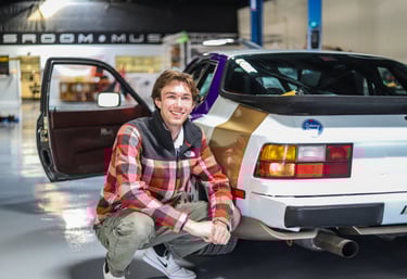 Luke Gilmore next to a Porsche 944.