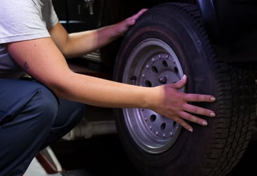 a person is holding a tire on a car