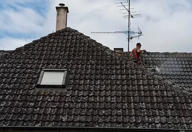Couvreur réalisant un nettoyage en profondeur d’une toiture envahie par les mousses à Montbéliard, pour restaurer l’étanchéit